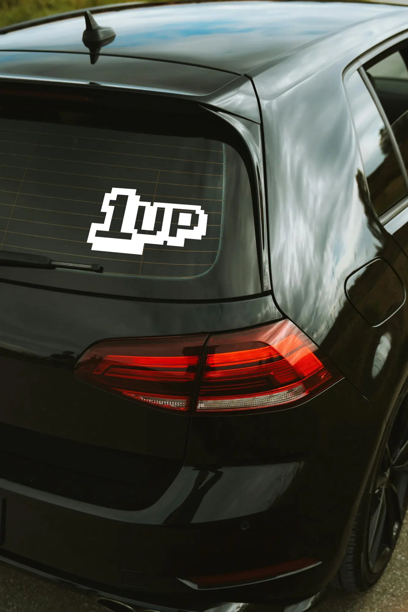 1up matrica fekete színben az autó hátsó ablakán.