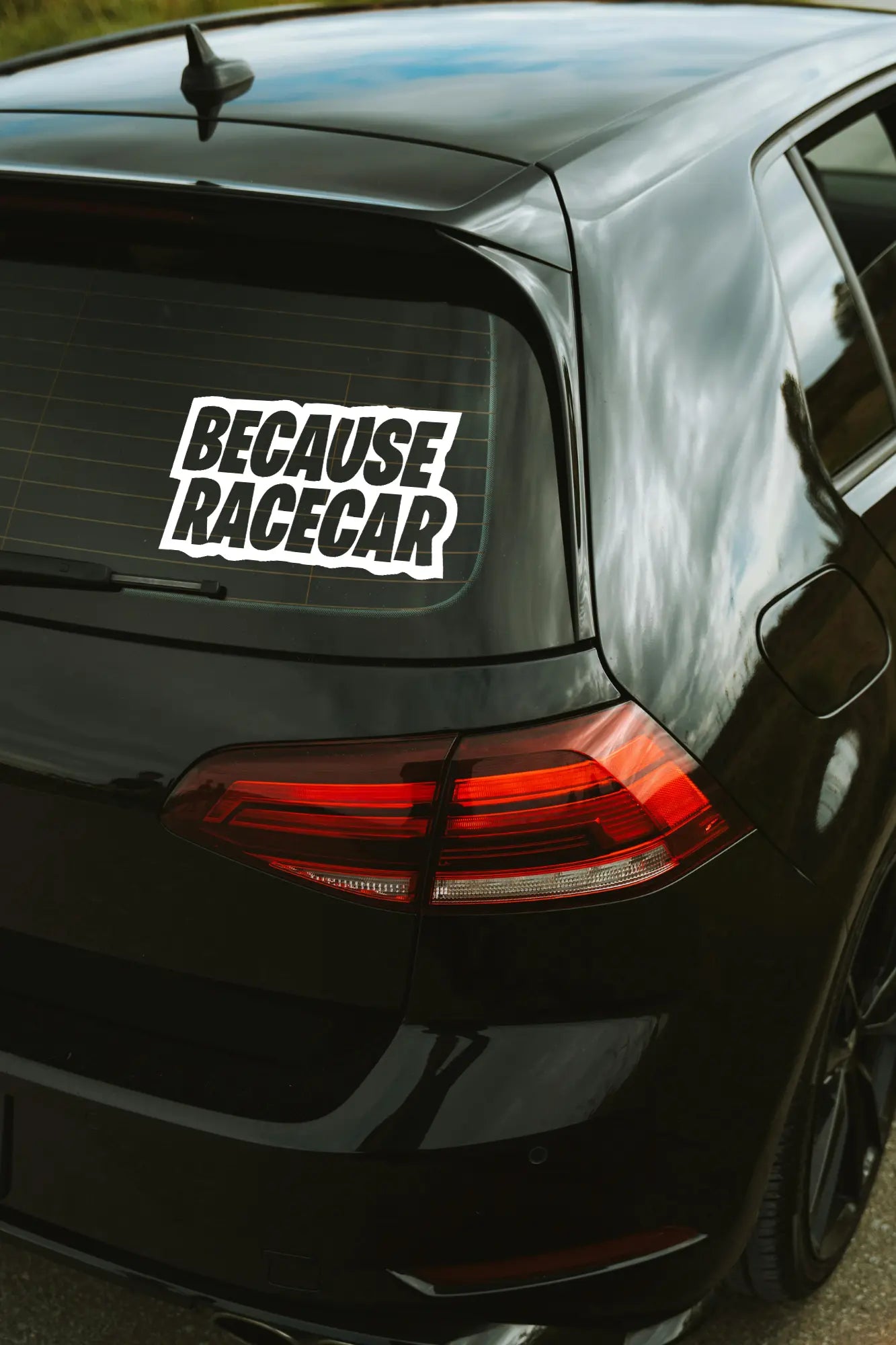 Because Racecar matrica fehér színben az autó hátsó ablakán.