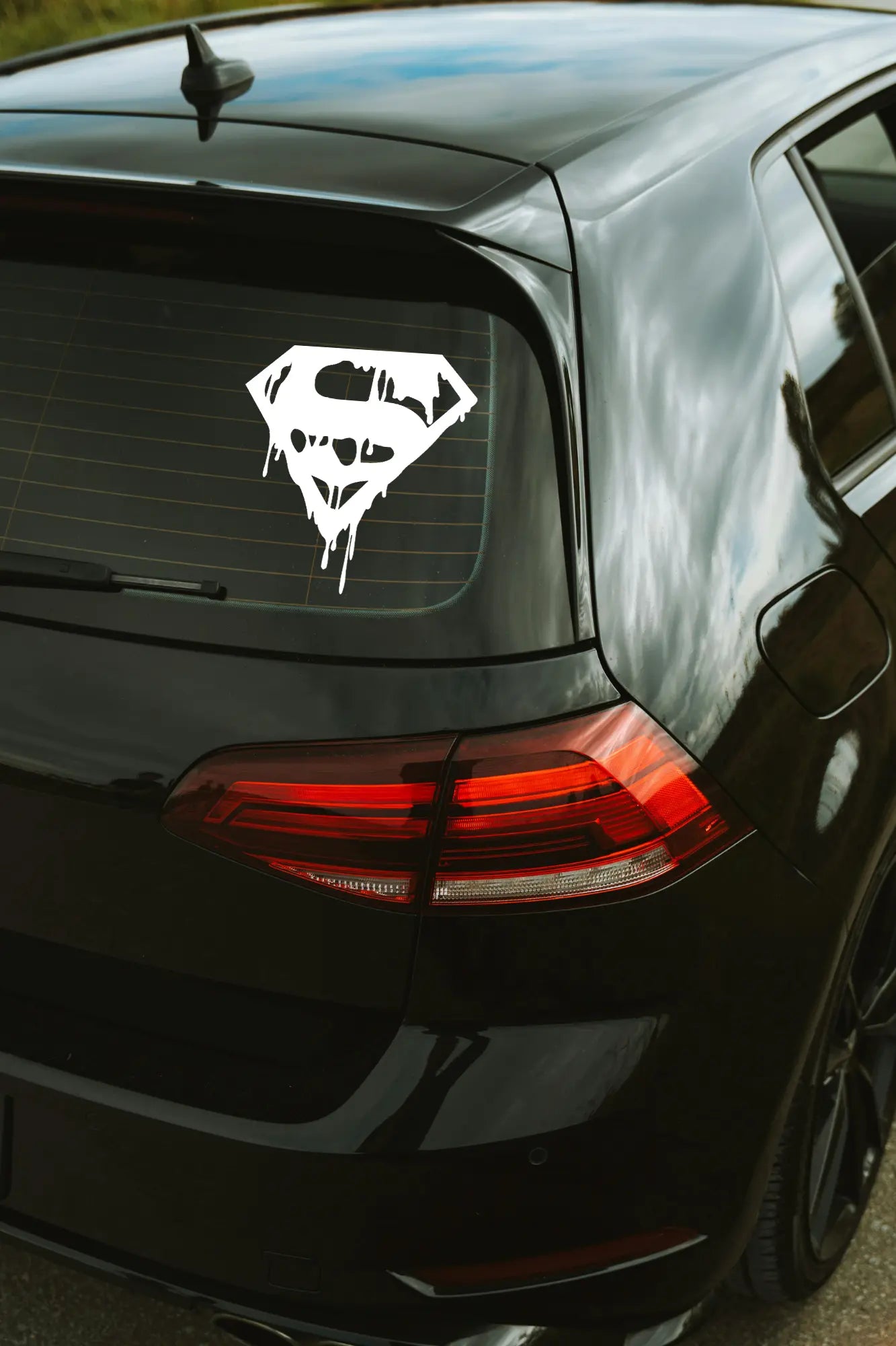 Bloody Superman matrica fehér színben az autó hátsó ablakán.