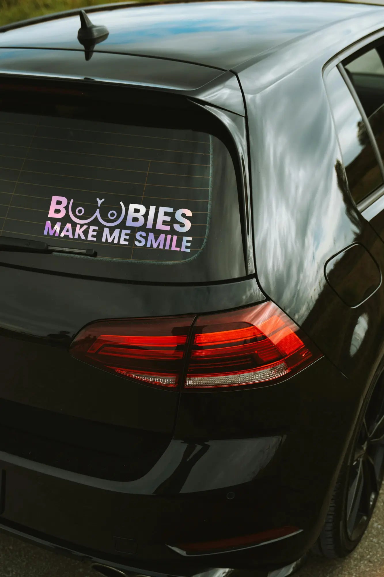 Boobies Make Me Smile matrica hologram színben az autó hátsó ablakán.