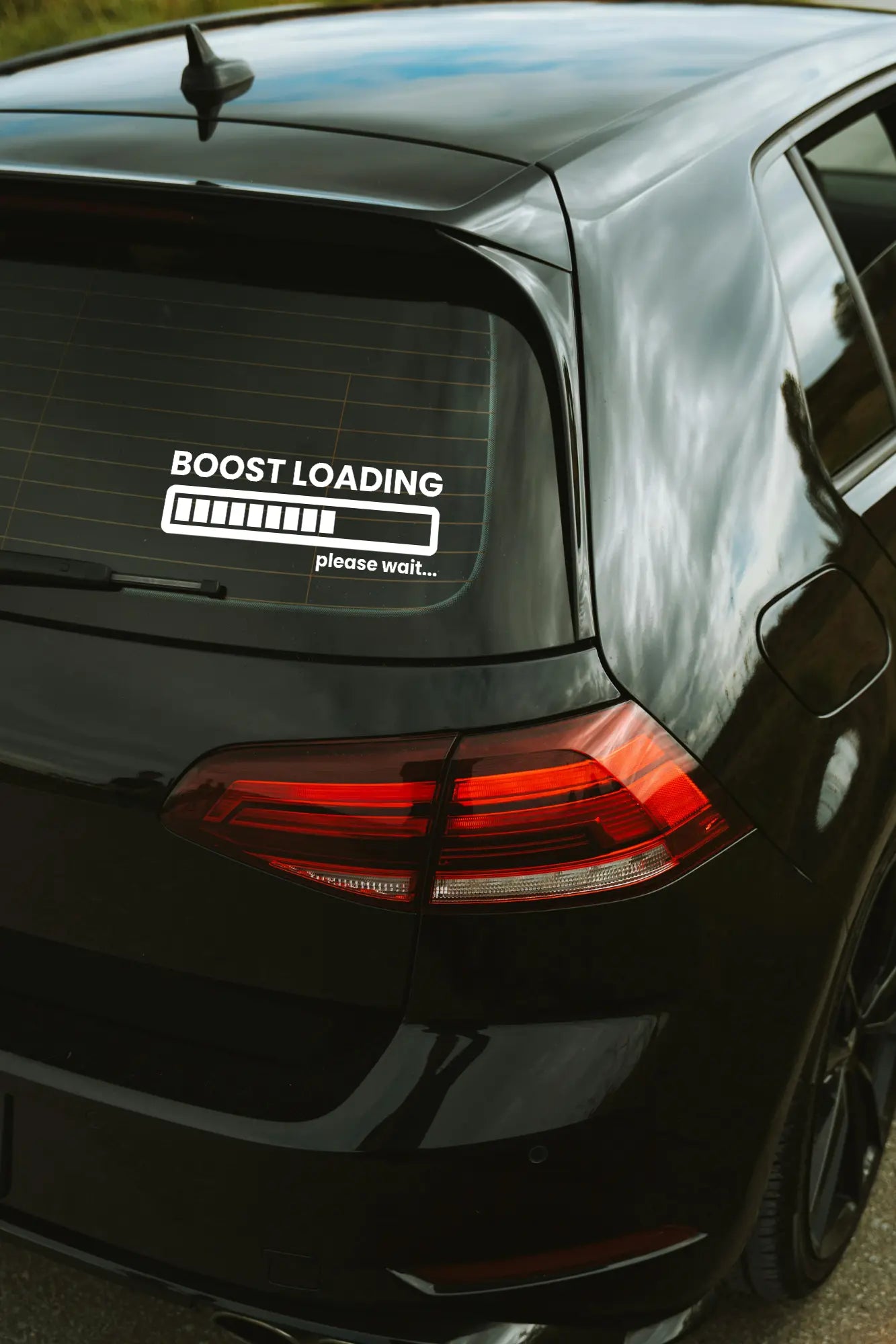 Boost Loading Please Wait... matrica fehér színben az autó hátsó ablakán.