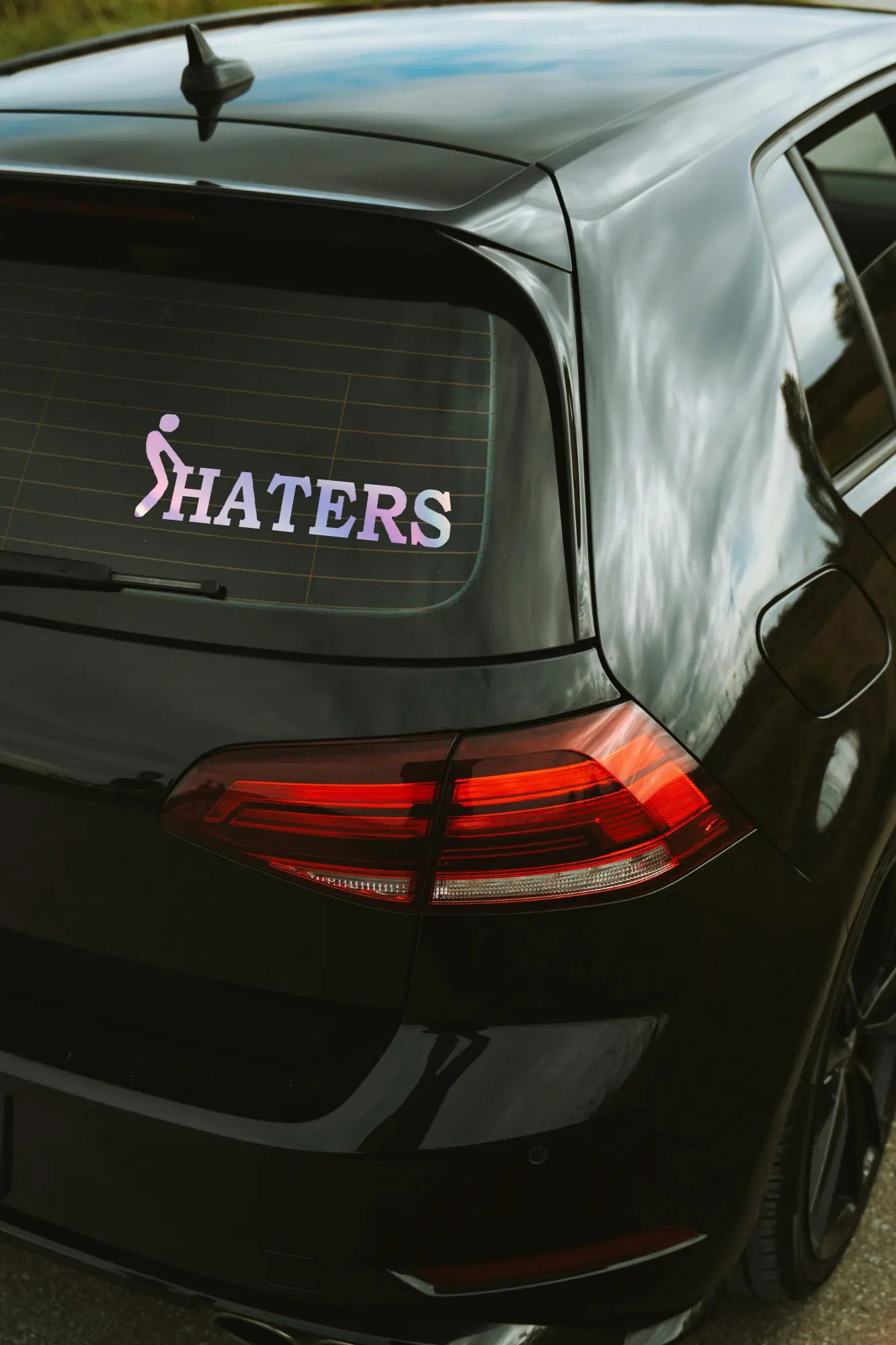 F*ck haters matrica hologram színben az autó hátsó ablakán.