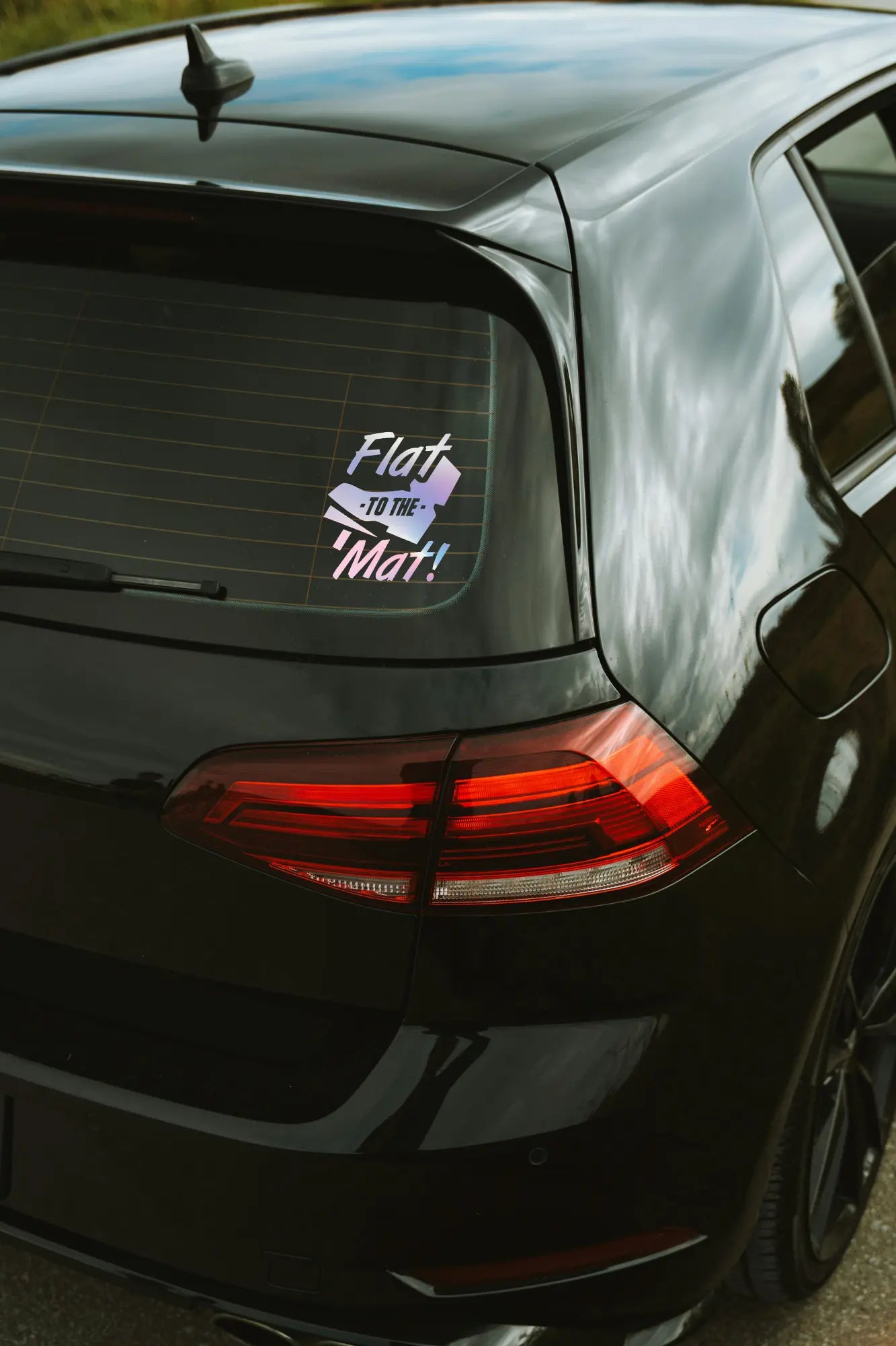 Flat to the mat! matrica hologram színben az autó hátsó ablakán.