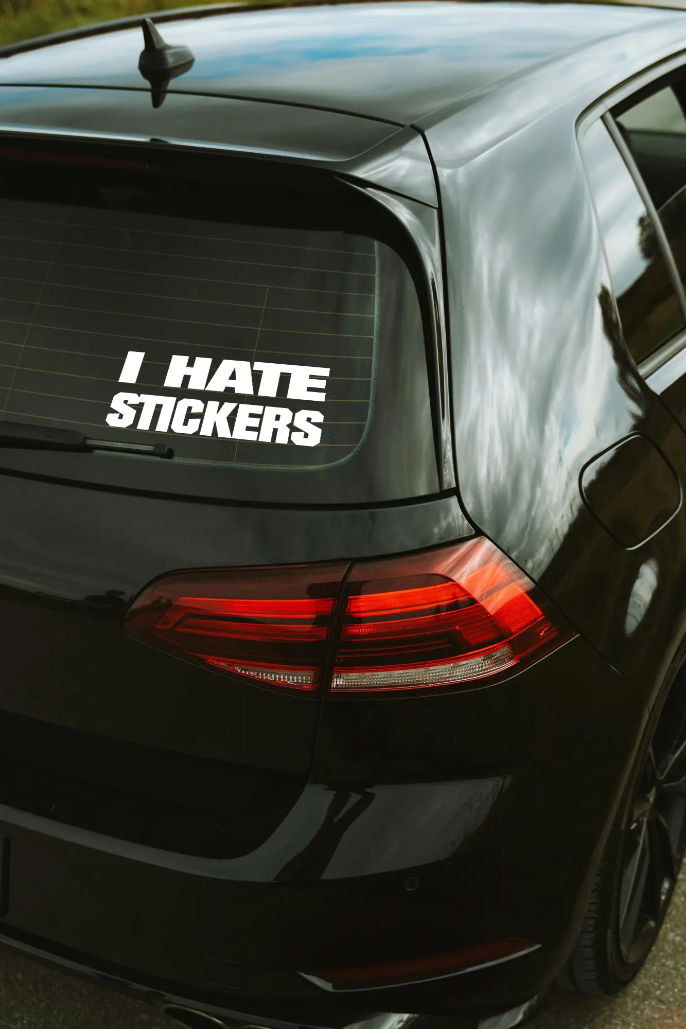 I Hate Stickers matrica fehér színben az autó hátsó ablakán.