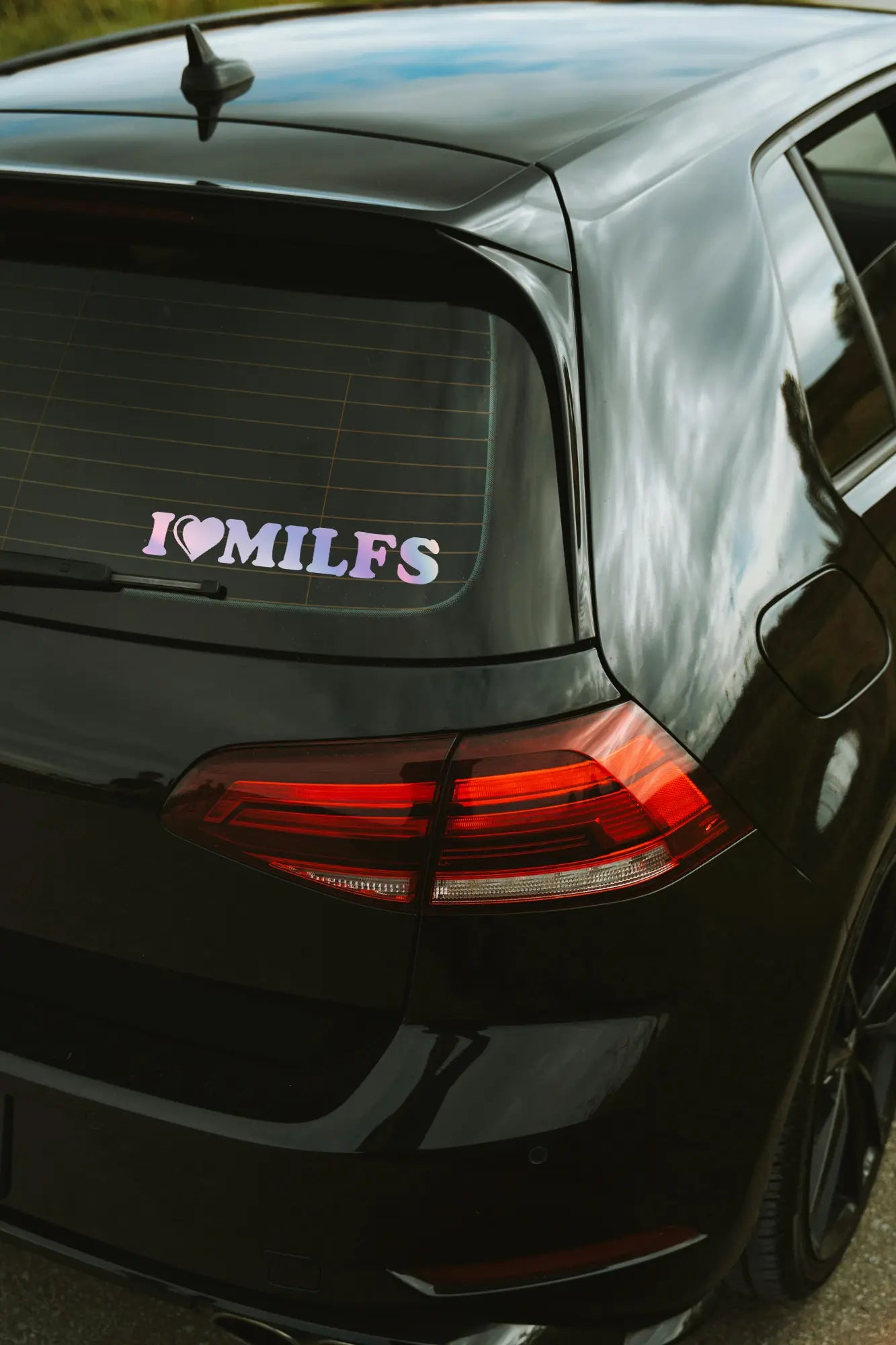 I Love Milfs matrica hologram színben az autó hátsó ablakán.
