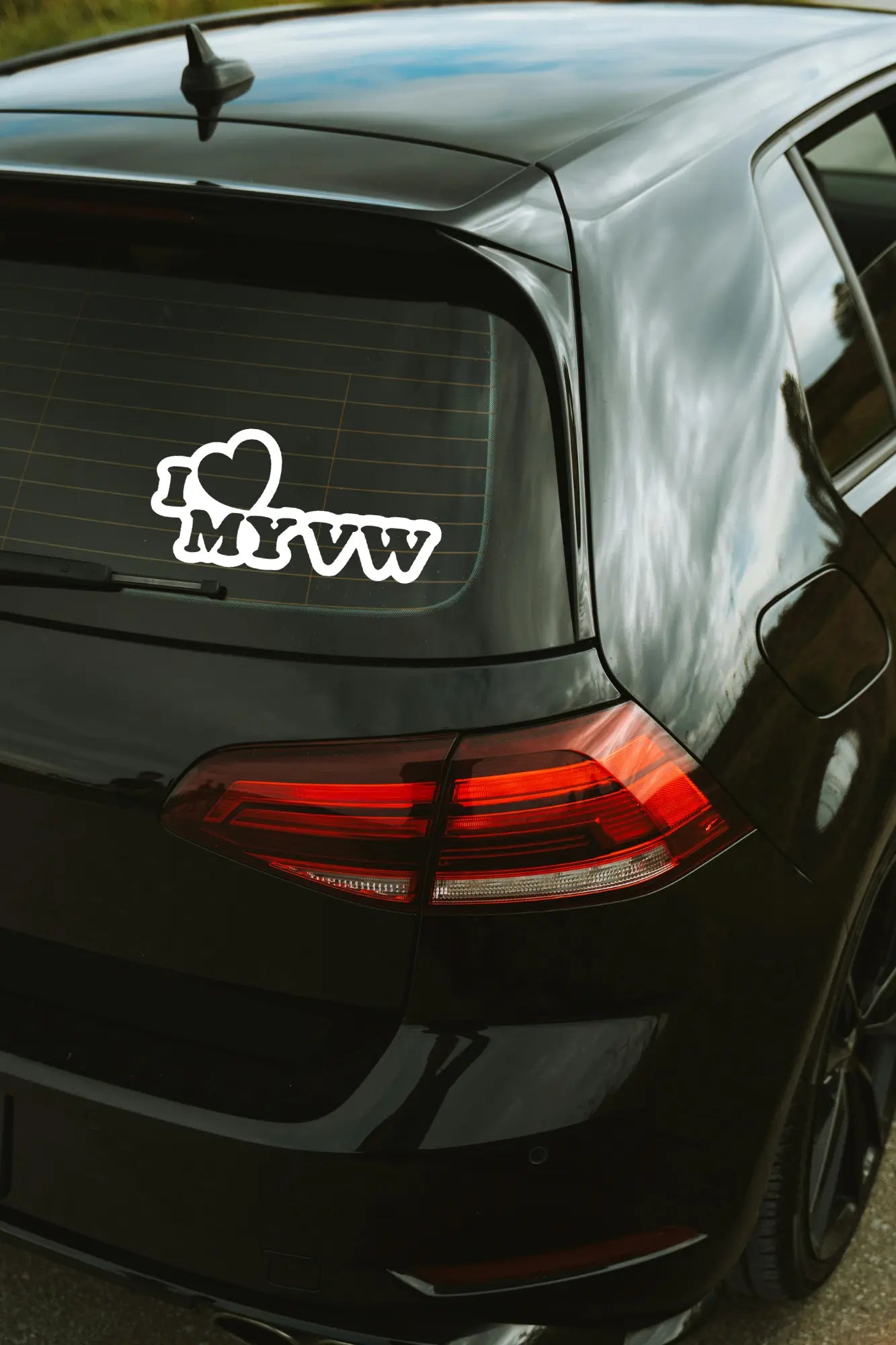 I love my VW matrica fehér színben az autó hátsó ablakán.
