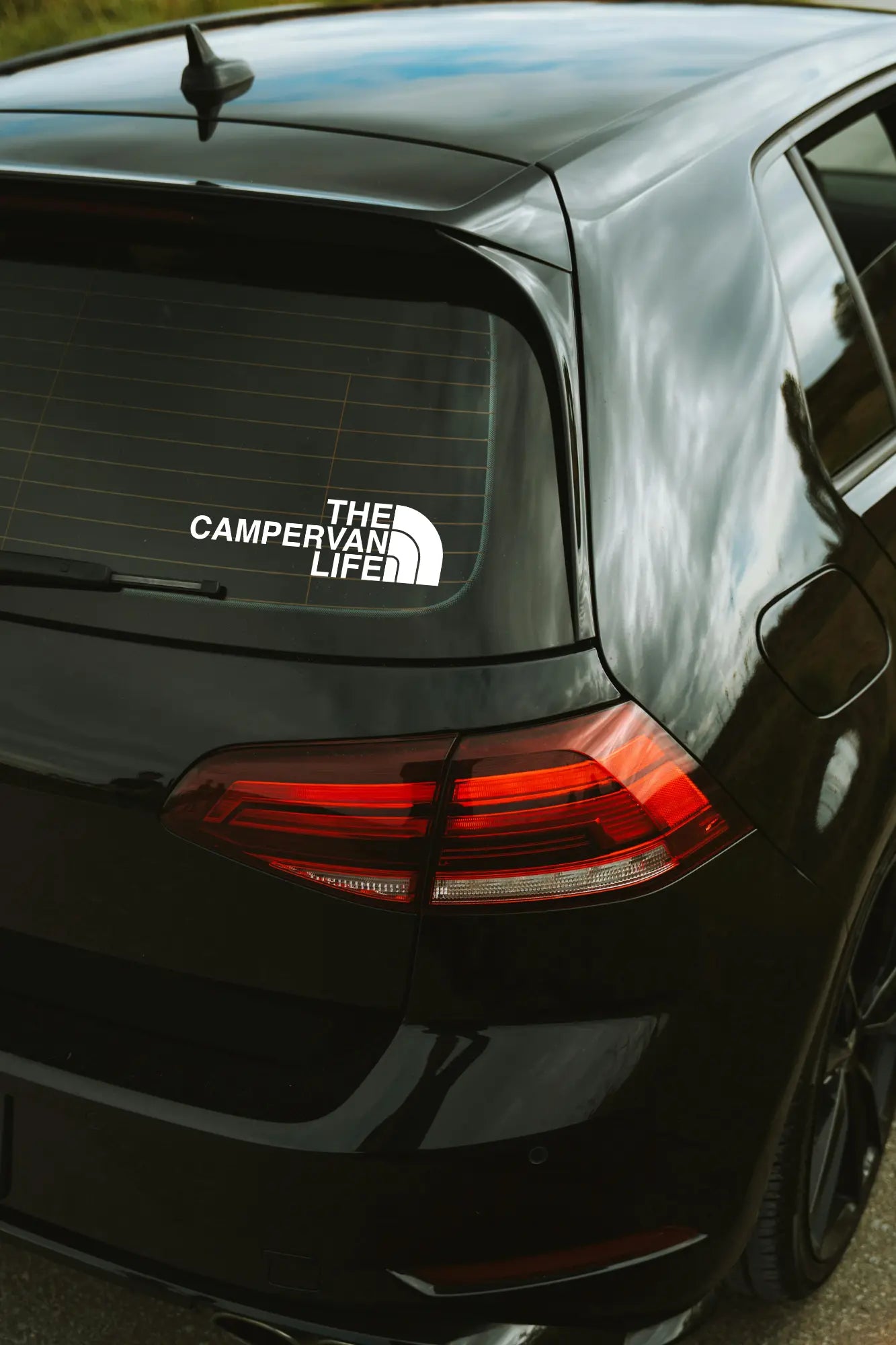 The Campervan Life matrica fehér színben az autó hátsó ablakán.