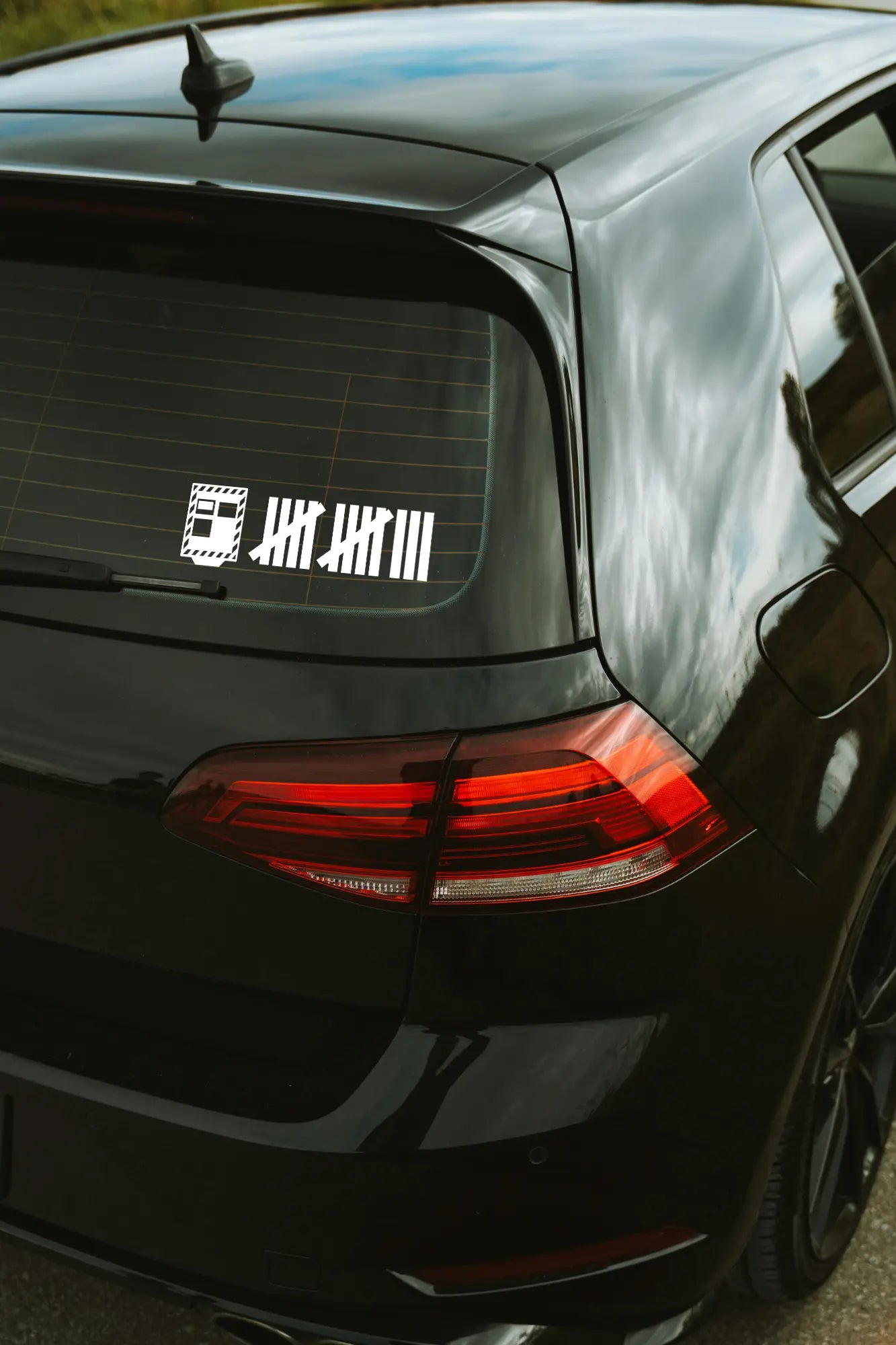 Traffipax strigulák matrica fehér színben az autó hátsó ablakán.