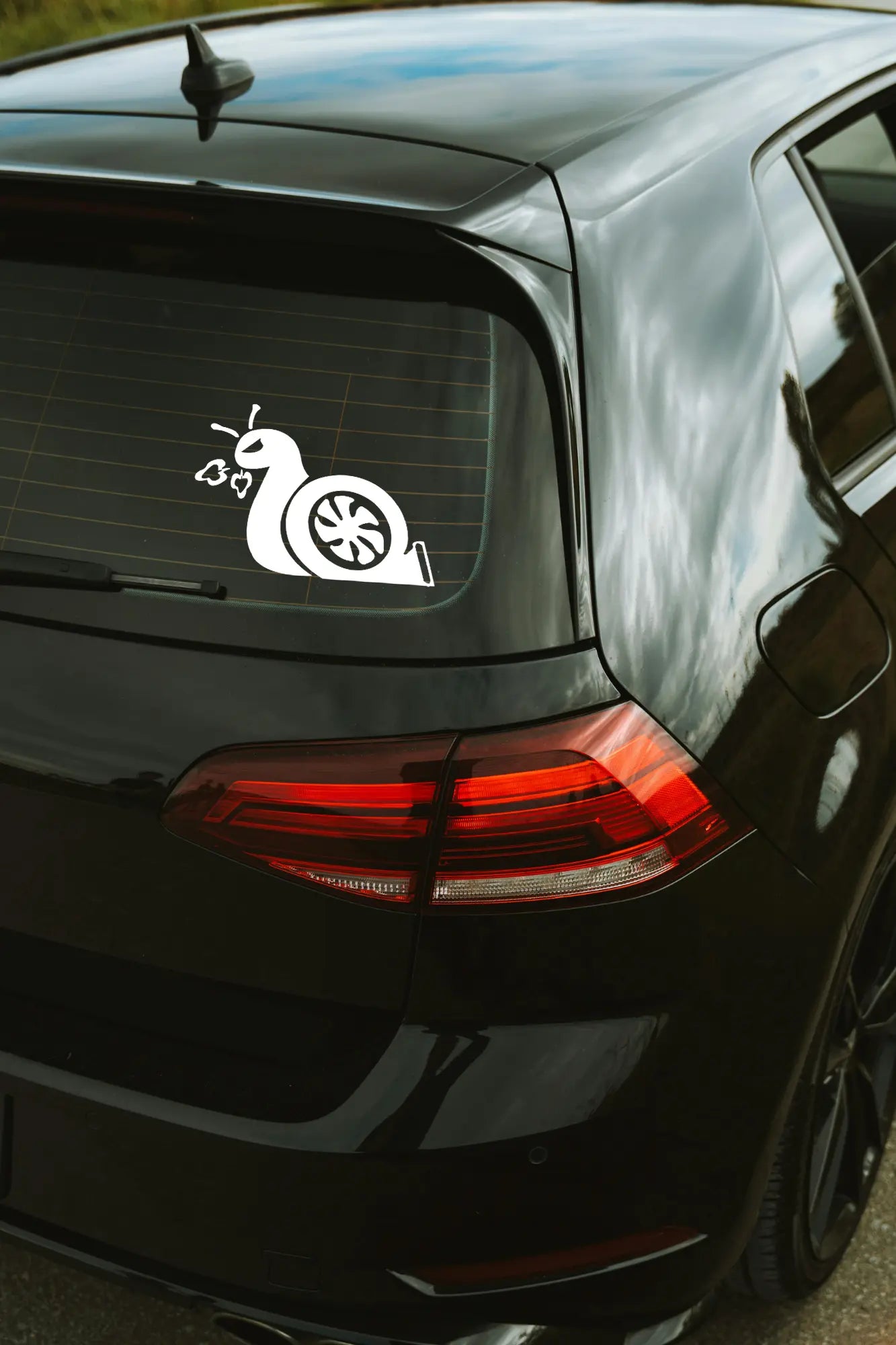Turbo csiga matrica fehér színben az autó hátsó ablakán.