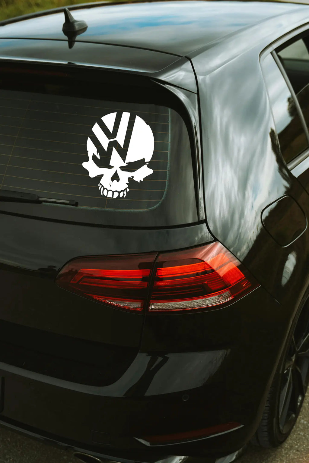 VW Koponya matrica fehér színben az autó hátsó ablakán.