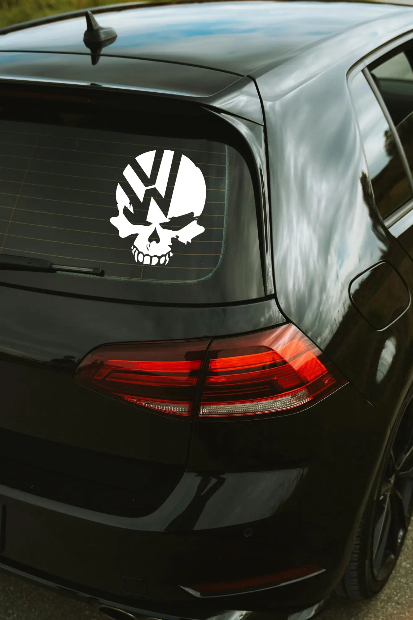 VW Koponya matrica fehér színben az autó hátsó ablakán.