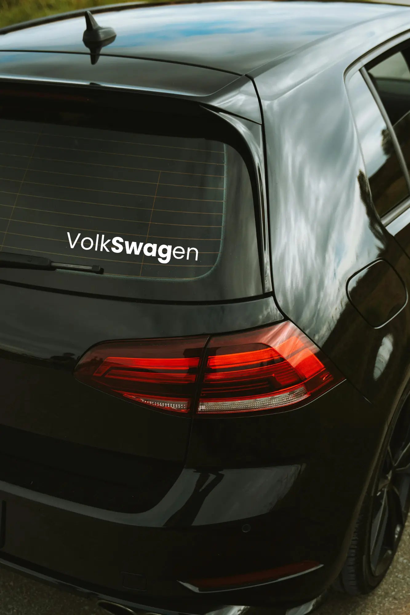 VolkSWAGen matrica fehér színben az autó hátsó ablakán.